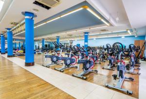 - une salle de sport avec de nombreuses rangées de tapis de course dans l'établissement Orange Volcano - pool, gym and activities in Sport Center Fariones included, à Puerto del Carmen