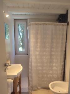 a bathroom with a shower curtain and a sink at Casa nueva en Bariloche a orillas del Nahuel Huapi in San Carlos de Bariloche
