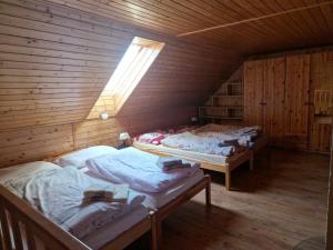 a attic room with three beds in a wooden building at Dubáčik Dovalovo in Liptovský Hrádok