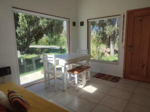 a white table and chairs in a room with a window at Casa nueva en Bariloche a orillas del Nahuel Huapi in San Carlos de Bariloche