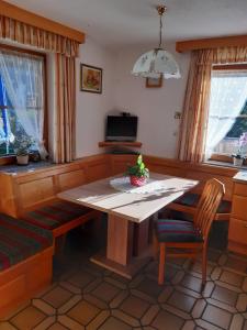 a dining room with a wooden table and chairs at Ferienwohnung Haus Bergfrieden in Gerlosberg