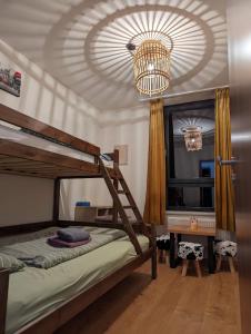a bedroom with a bunk bed and a chandelier at Zadov - Apartmán Srdce Šumavy in Stachy