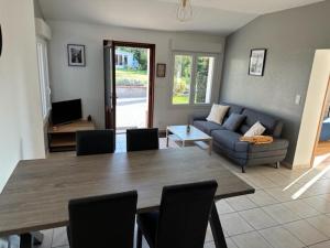 a living room with a table and a couch at Le Nid Du Moulin in Batzendorf