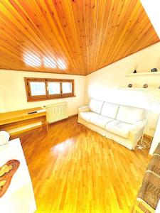 a living room with a couch and a wooden ceiling at 4 minuti dalla stazione Loft moderno in Pontassieve +1 photo
