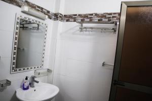 ein weißes Badezimmer mit einem Waschbecken und einem Spiegel in der Unterkunft Chez Mamanta in St. Louis