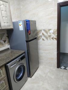 a refrigerator in a kitchen with a washing machine at شقة فاخرة مع مطل in Amman