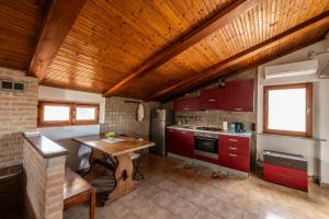 eine Küche mit roten Schränken und einer Holzdecke in der Unterkunft L'Oasi di Ramona in Polesine Parmense