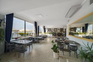 un restaurante con mesas, sillas y ventanas en Marina Diana, en Białobrzegi