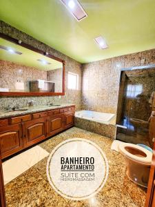 a bathroom with a sink and a toilet and a mirror at Hotel Negreiros in São Lourenço