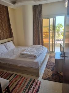 a bedroom with a bed and a sliding glass door at Casablanca Beach for families and couples only in Hurghada