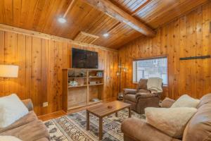 sala de estar con paredes revestidas de madera y TV en The Alaskan Dream Lodge, en Fairbanks