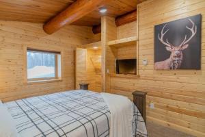 1 dormitorio con 1 cama y una foto de un ciervo en la pared en The Alaskan Dream Lodge en Fairbanks