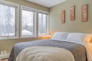 1 dormitorio con 1 cama y 2 ventanas en The Airport Chalet en Fairbanks