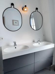 ein Badezimmer mit zwei Waschbecken und zwei Spiegeln in der Unterkunft Wambrechies centre maison 3 chb in Wambrechies