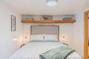 ein Schlafzimmer mit einem Bett mit einer grünen Decke darauf in der Unterkunft The Little Airport Getaway in Fairbanks