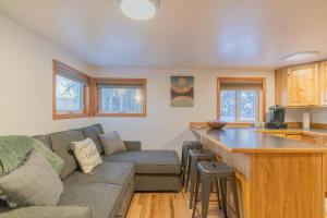 a living room with a couch and a kitchen at The Little Airport Getaway in Fairbanks