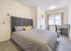 a bedroom with a large bed and a desk at Regent House - Modern Holiday Home 10 Minutes to Manchester City Centre With Free Parking in Manchester