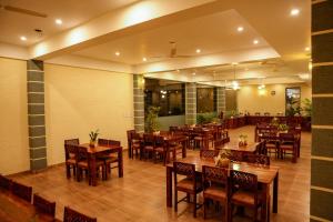 un restaurante vacío con mesas y sillas de madera en Amar Bagh Resort, en Pushkar