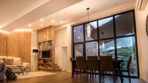 a dining room and living room with a large window at Casas da Ribeira - Porto Bay Villa in Porto Formoso