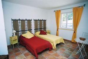 a bedroom with two beds and a window at Le Mas de Bel Air in Pierrerue