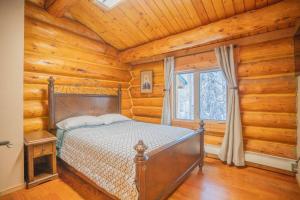 1 dormitorio con 1 cama en una habitación con paredes de madera en Tucked Away Timber Upper Suite, en Fairbanks