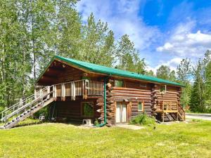 Cabaña de madera con porche y escalera en Tucked Away Timber Upper Suite, en Fairbanks