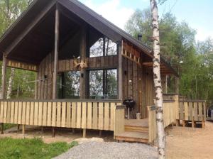 une cabane en bois avec un arbre dans l'établissement Inarin Kalakenttä, à Inari