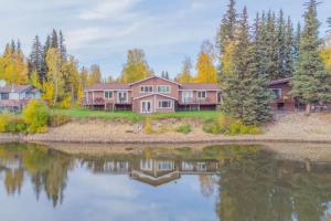 a large house with a lake in front of it at The Chena River House South Suite in Fairbanks
