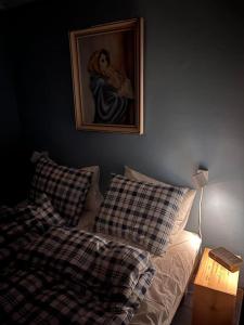 Kvaløya的住宿－Kvaløyvågen Gård AS，卧室配有一张床,墙上挂有绘画作品