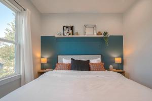 1 dormitorio con 1 cama grande y cabecero azul en Boho Chic Retreat with Unique Photo Op, King Bed, Private Backyard & Free Parking - 8 Mins from Downtown! en Houston