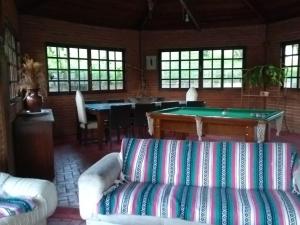 a living room with a couch and a pool table at Lindo Sitio Junto à Natureza in Ibiúna