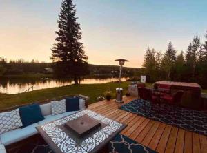 - un patio avec un canapé et une table sur une terrasse en bois dans l'établissement Life is Better on the River, à Fairbanks