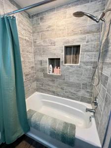 a bathroom with a bath tub and a shower at Life is Better on the River in Fairbanks +33 photos