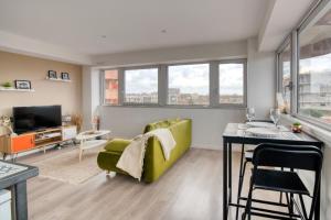 a living room with a green couch and a table at BD MINIMES - Parking Free - Proche gare - Vue in Toulouse