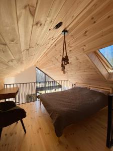 Posto letto in camera con soffitto in legno. di Mała Holenderka - Lewy Brzeg Narwi a Burlaki