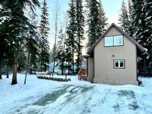 ein kleines Haus im Schnee mit Bäumen in der Unterkunft Northern Lights Layover in Fairbanks