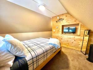 ein Schlafzimmer mit einem Bett und einer Wand mit einem Fenster in der Unterkunft Northern Lights Layover in Fairbanks