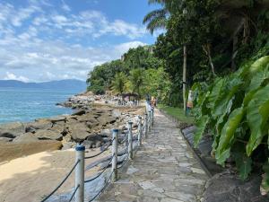 a stone path next to a beach with the ocean at Apto Porto Real Resort Angra in Mangaratiba