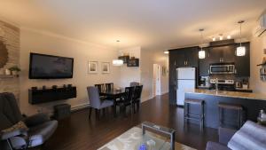 a kitchen and living room with a table and chairs at Le 204 Champlain Bromont in Bromont