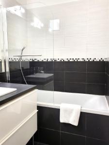 a white bathroom with a tub and a sink at FAC 4 - Tram au pied l'immeuble- Parking free in Toulouse