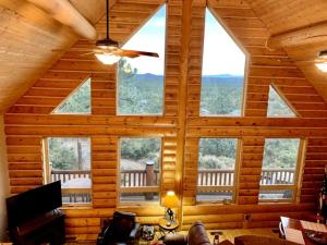 um quarto com janelas grandes num chalé de madeira em Hilltop Chalet-Stunning Views, 3mi from downtown em Prescott