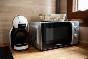 un microondas y una cafetera en una encimera en Apartamentos GEMINA, en Mérida