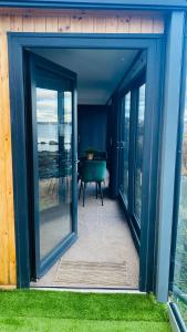 an open glass door of a house with a table at Luxury beach front rooms- PMA in Kirkcaldy