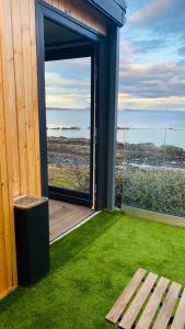 a room with an open door with a view of the ocean at Luxury beach front rooms- PMA in Kirkcaldy