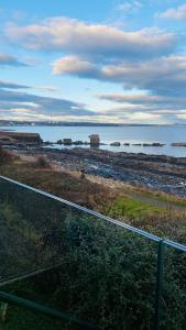 a view of the ocean from a balcony at Luxury beach front rooms- PMA in Kirkcaldy