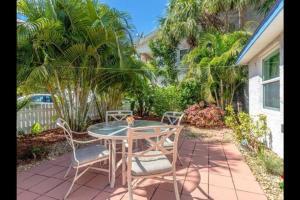 a patio with a table and chairs and palm trees at Beachy Paradise in Clearwater Beach