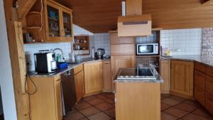 a small kitchen with wooden cabinets and a sink at Schöne 4-Zimmer-Ferienwohnung zu vermieten in Löffingen