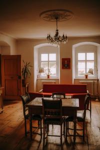 une salle à manger avec une table, des chaises et un lustre dans l'établissement BioRezydencja, à Świeradów-Zdrój