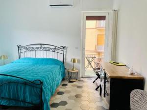 een slaapkamer met een bed, een bureau en een raam bij chiesa russa in Bari