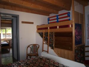 a bedroom with a bunk bed and a chair at Al Piazzo 414 in Brusio